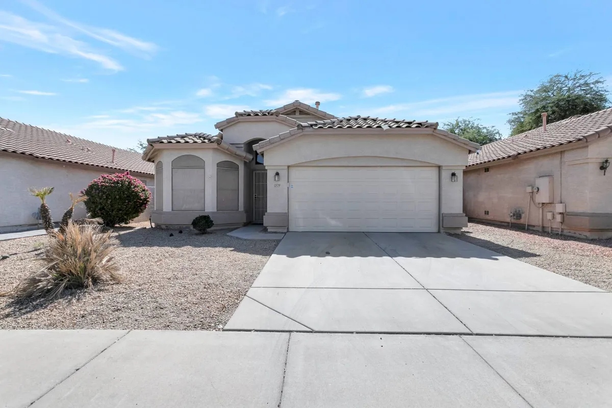 The image shows the inviting front facade of the Avondale home, complete with a landscaped yard and a welcoming entrance. The garage door and front porch are visible amid a neighborhood setting, suggesting a family-friendly environment that serves as the perfect base for a Phoenix adventure.